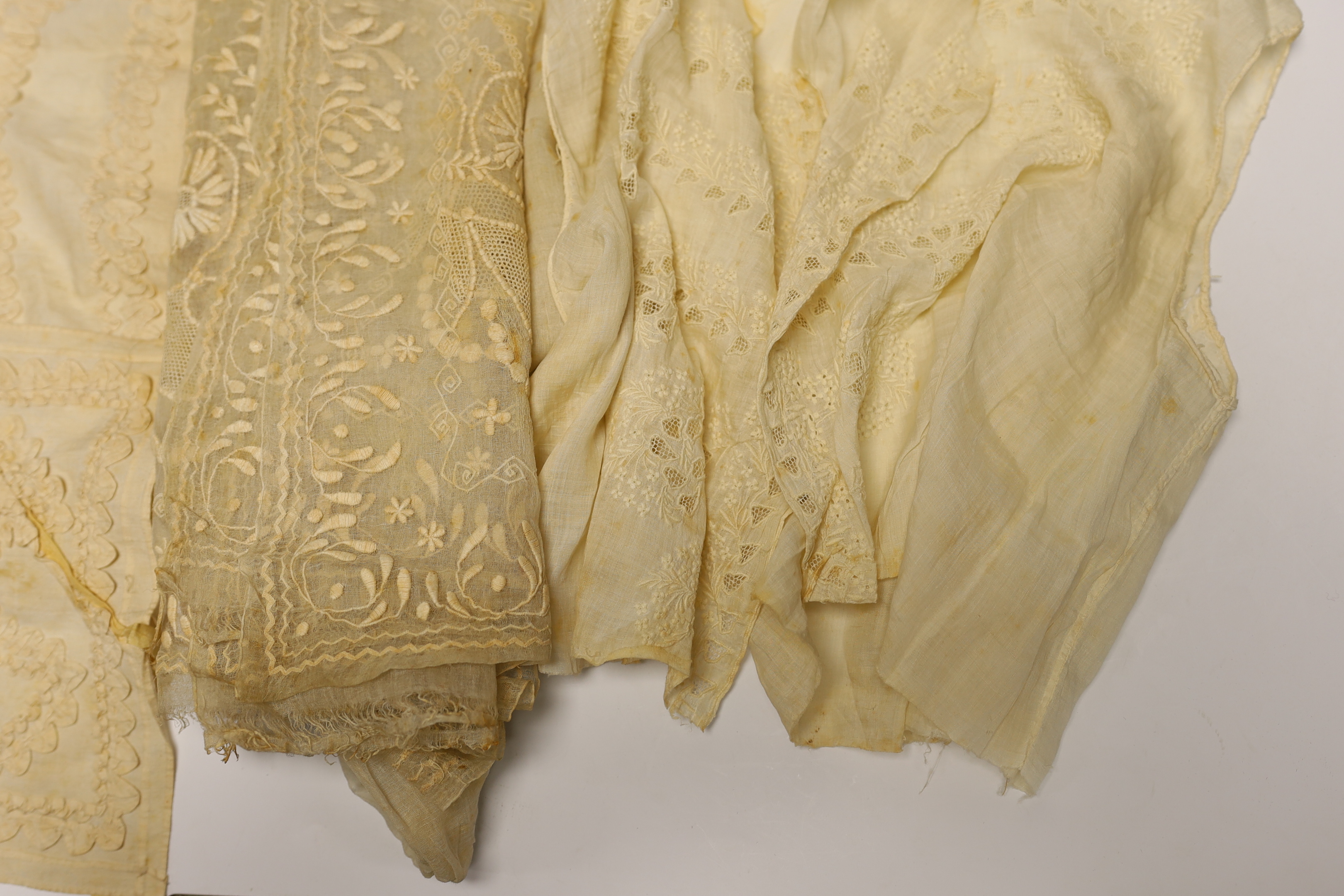 An 18th century Dresden worked apron, a white worked fine lawn stole, two panels of linen ribbon work, a ladies lace bonnet a similar pink satin bonnet a white worked blouse (partially made) and panel to a christening go